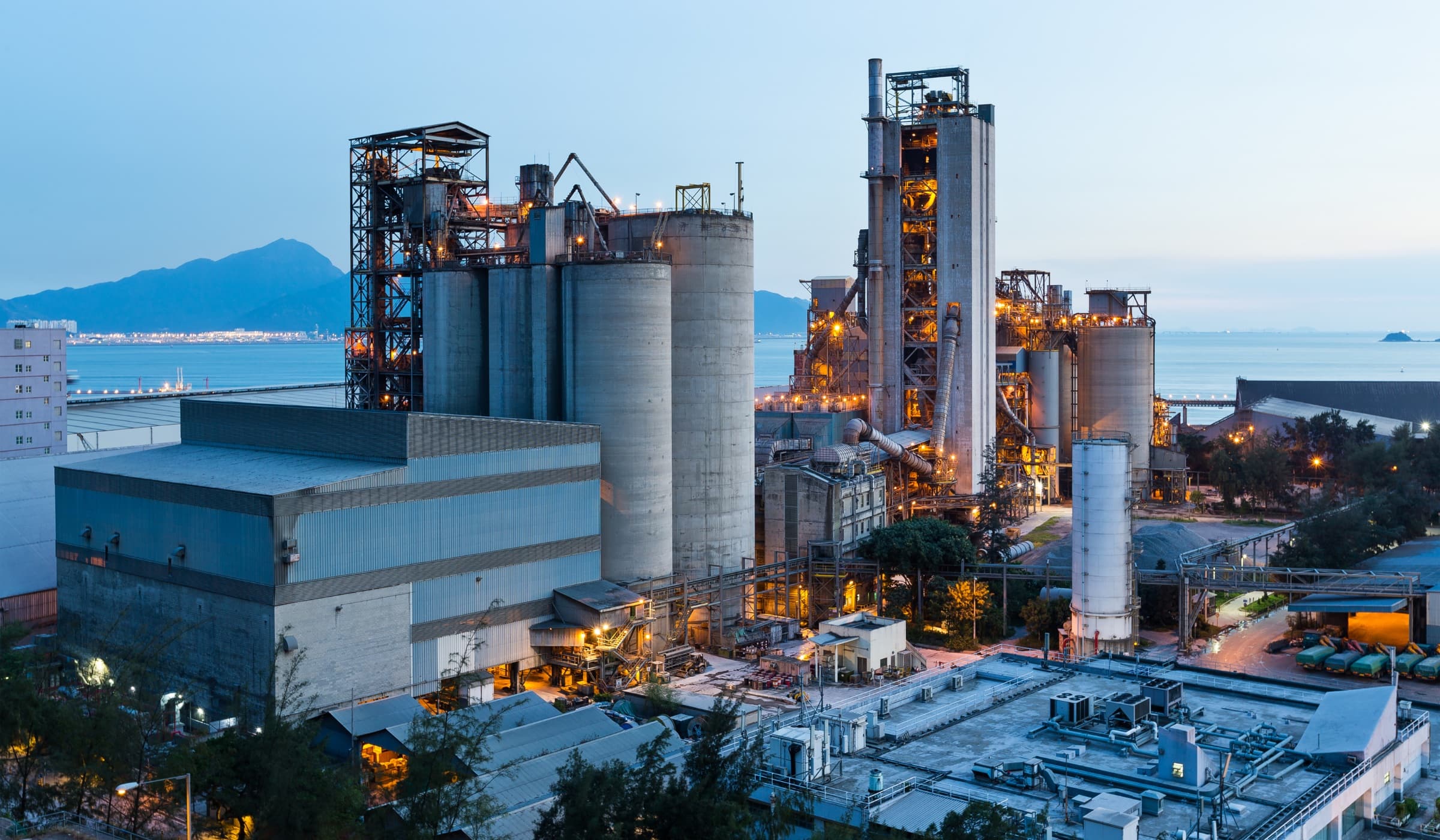 Large industrial manufacturing facility operating beside a coastal trade route