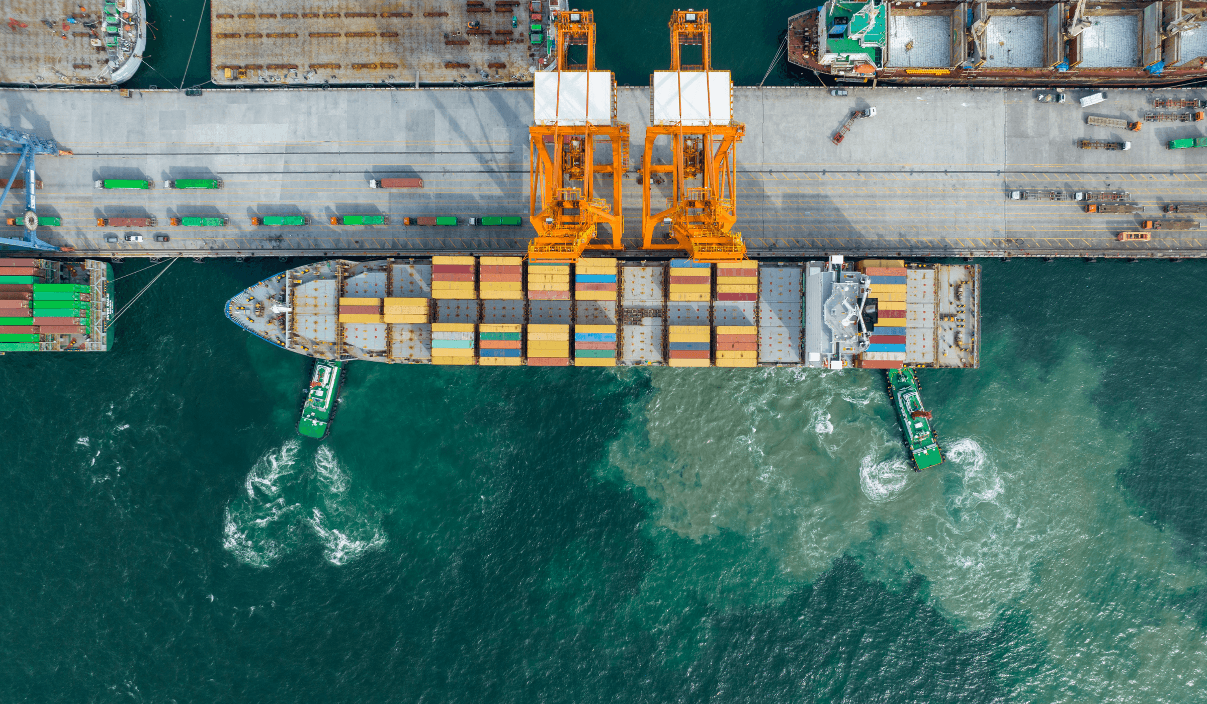 Aerial view of a container ship being handled by cranes at a port terminal
